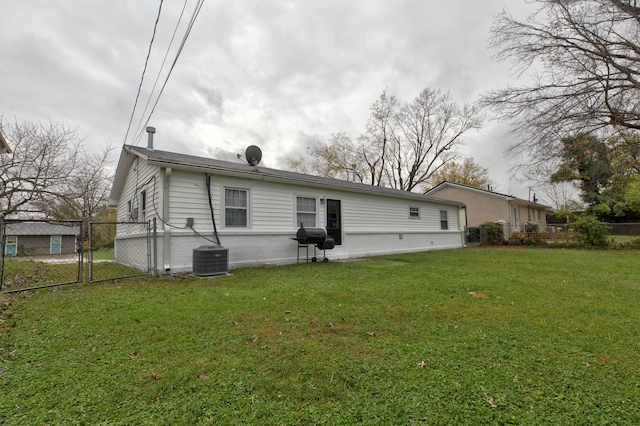 back of property featuring central AC unit and a lawn