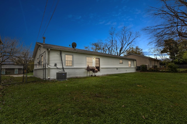 rear view of house with a yard and central AC