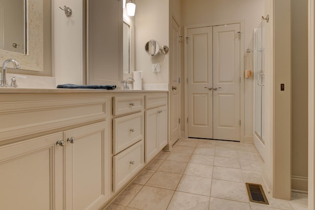 bathroom with tile patterned flooring, vanity, and a shower with shower door