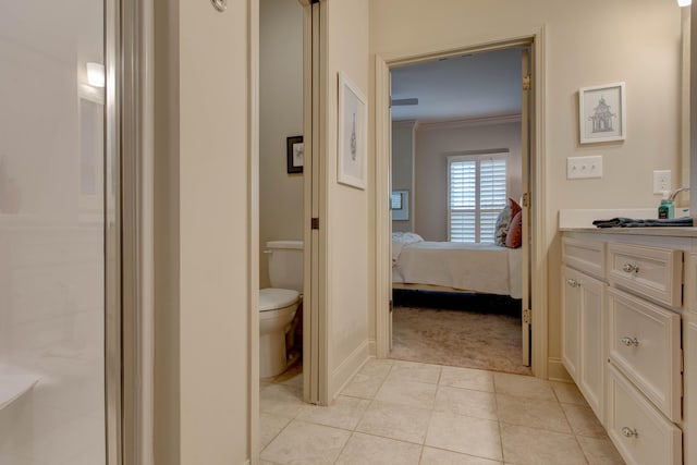 bathroom featuring tile patterned flooring, toilet, vanity, a shower with shower door, and ornamental molding