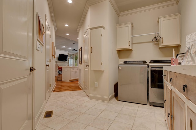 laundry room featuring cabinets, ceiling fan, washing machine and dryer, ornamental molding, and light tile patterned floors