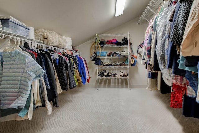 spacious closet with carpet flooring and vaulted ceiling