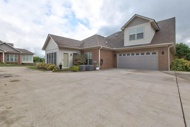 view of front of property featuring a garage and cooling unit