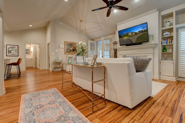 living room featuring ceiling fan, light hardwood / wood-style floors, and vaulted ceiling