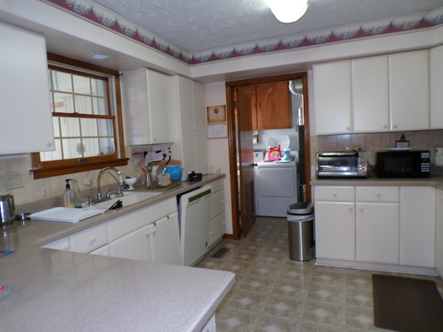 kitchen with a textured ceiling, sink, dishwasher, washer / clothes dryer, and white cabinetry