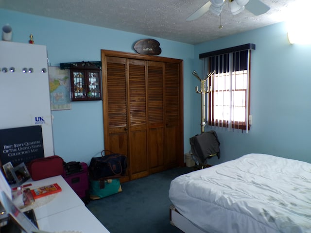 bedroom with carpet flooring, ceiling fan, a closet, and a textured ceiling