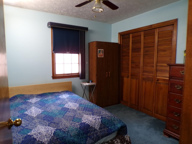 bedroom with dark colored carpet, a textured ceiling, a closet, and ceiling fan