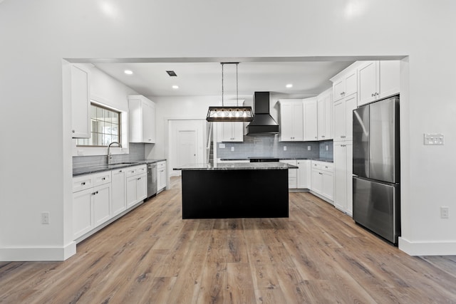 kitchen featuring decorative light fixtures, white cabinets, a center island, stainless steel appliances, and custom range hood