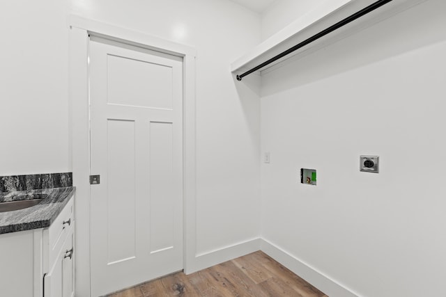 washroom featuring hookup for a washing machine, sink, hookup for an electric dryer, and light hardwood / wood-style flooring