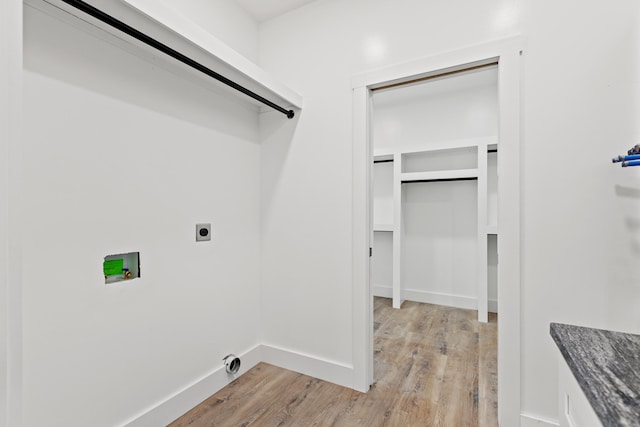 washroom with hookup for an electric dryer, light hardwood / wood-style floors, and hookup for a washing machine