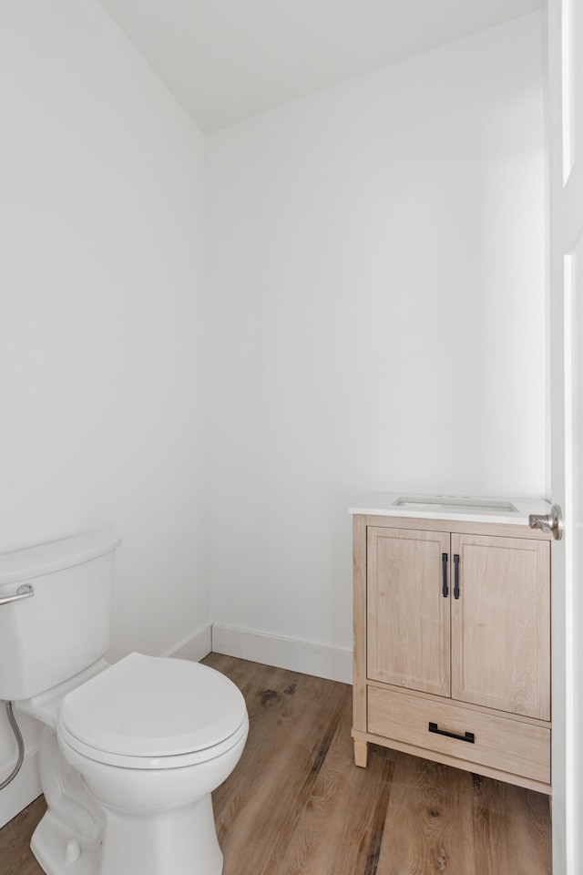 bathroom with toilet and hardwood / wood-style floors