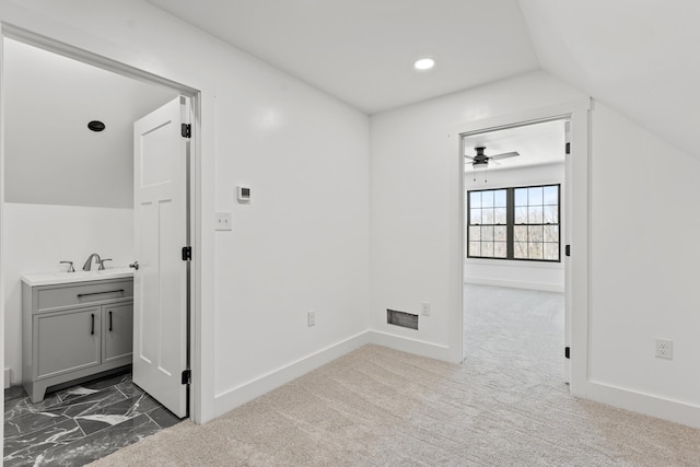 corridor with lofted ceiling and dark colored carpet