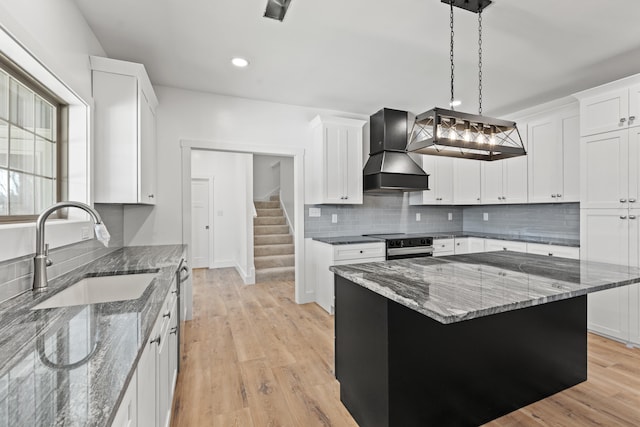 kitchen with white cabinetry, sink, custom range hood, and electric range