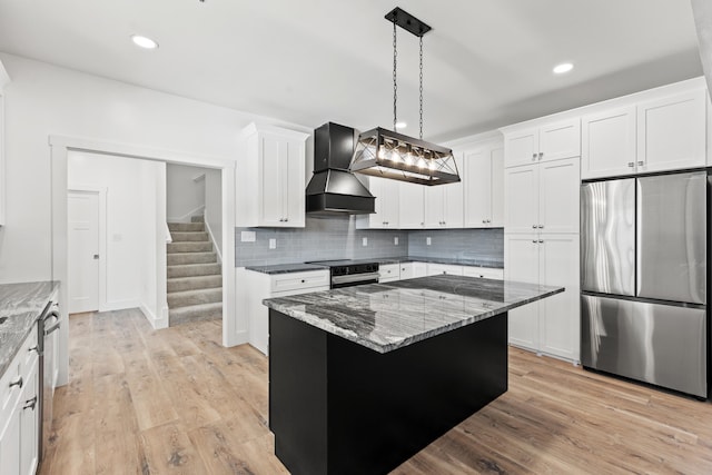 kitchen with premium range hood, decorative light fixtures, white cabinetry, a center island, and stainless steel appliances