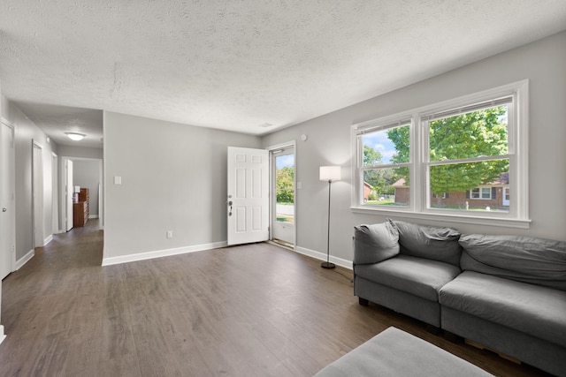 unfurnished living room featuring dark hardwood / wood-style flooring and a textured ceiling