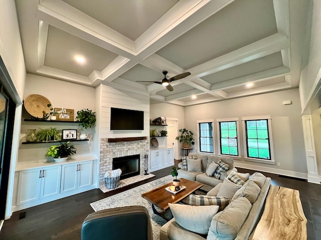 living room featuring beamed ceiling, dark hardwood / wood-style floors, a brick fireplace, and coffered ceiling