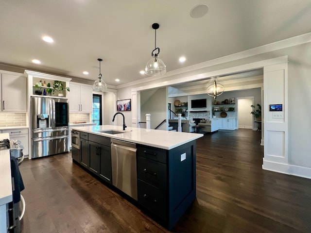 kitchen featuring decorative backsplash, appliances with stainless steel finishes, dark hardwood / wood-style flooring, a kitchen island with sink, and white cabinetry