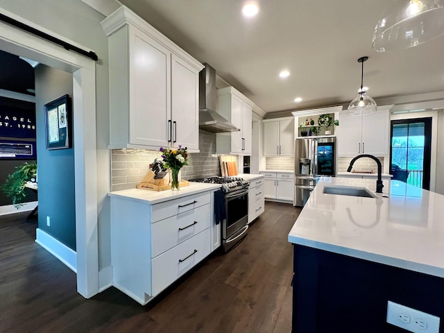 kitchen with white cabinets, appliances with stainless steel finishes, wall chimney exhaust hood, and sink