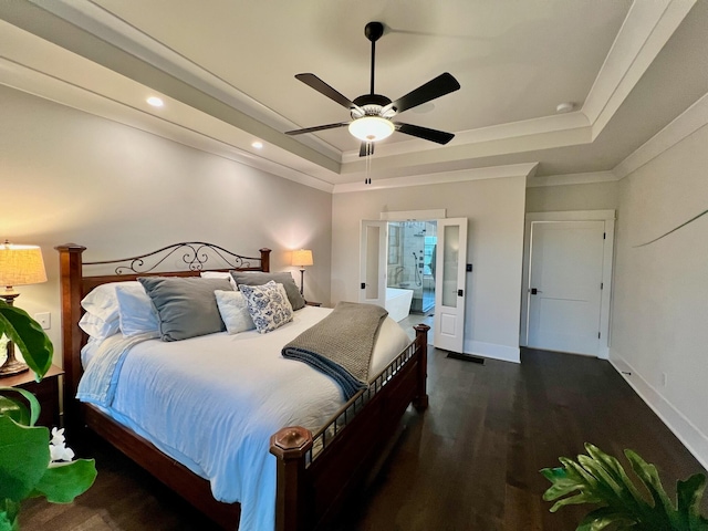 bedroom featuring a raised ceiling, ensuite bathroom, ceiling fan, and dark hardwood / wood-style floors