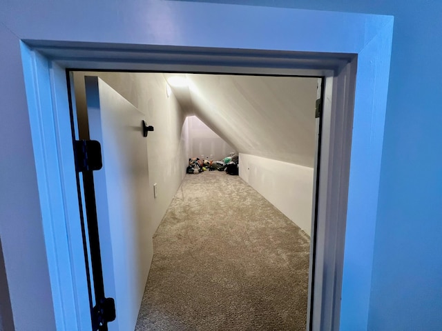 hallway featuring carpet and lofted ceiling