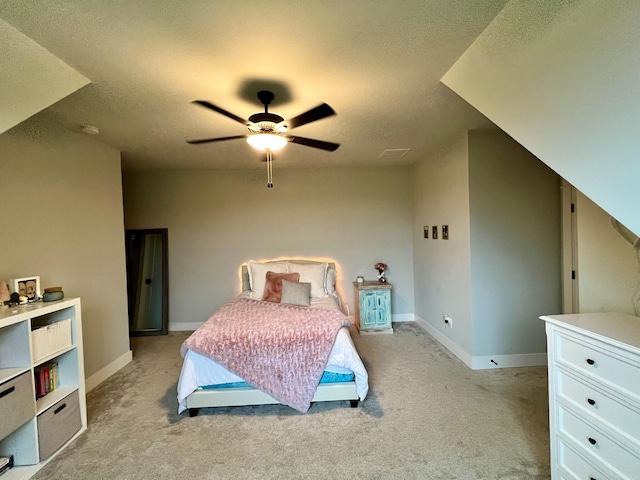 carpeted bedroom featuring ceiling fan and a textured ceiling