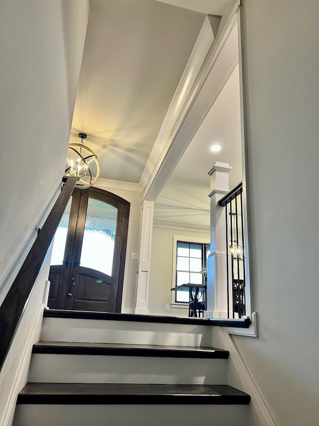 staircase with a notable chandelier