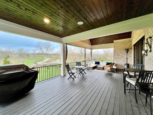 wooden deck with outdoor lounge area and a grill