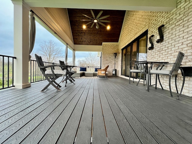 wooden deck featuring outdoor lounge area and ceiling fan