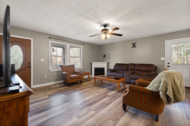 living room featuring hardwood / wood-style floors, plenty of natural light, ceiling fan, and a textured ceiling