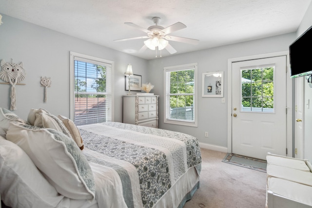 bedroom with multiple windows, ceiling fan, and light colored carpet