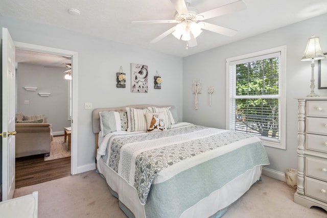 bedroom with ceiling fan and light carpet