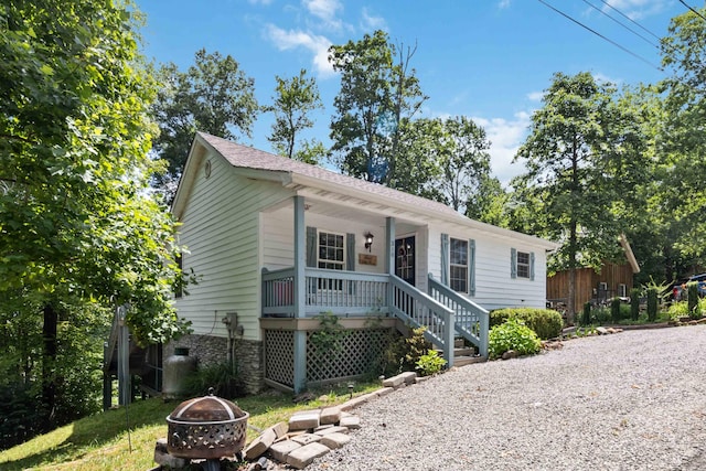 ranch-style home with covered porch and an outdoor fire pit