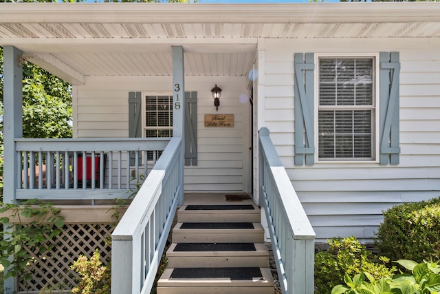 view of exterior entry featuring covered porch