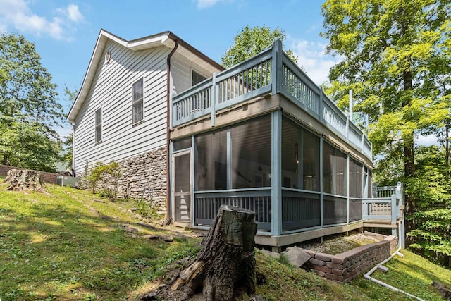 rear view of house with a lawn, a sunroom, and central AC unit