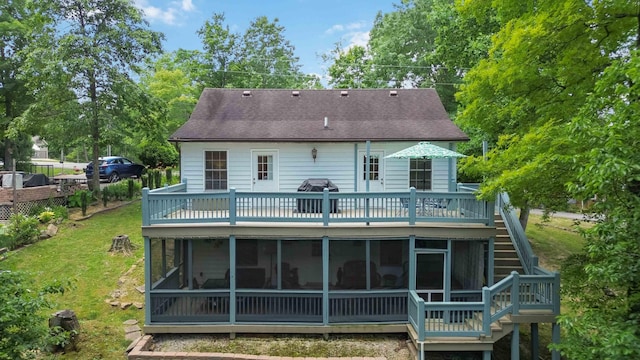 back of property with a yard, a wooden deck, and a sunroom