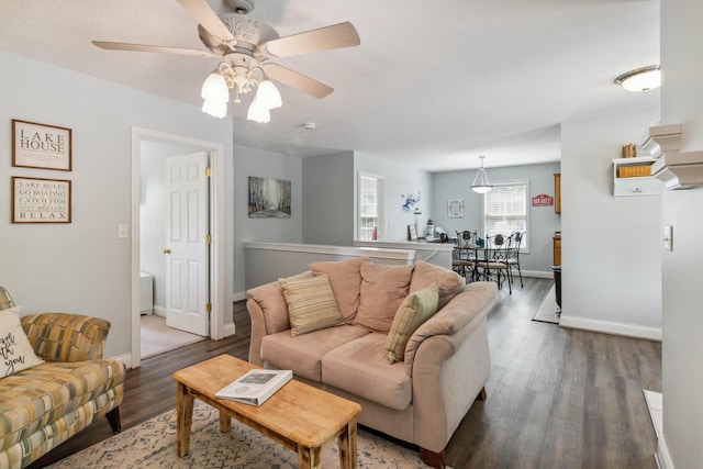 living room featuring ceiling fan and dark wood-type flooring