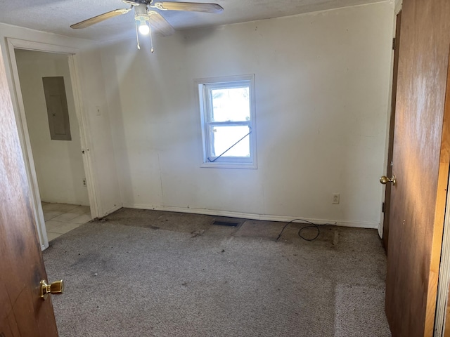 carpeted spare room featuring ceiling fan and electric panel