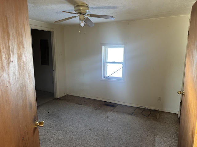 unfurnished room with a textured ceiling, ceiling fan, and carpet