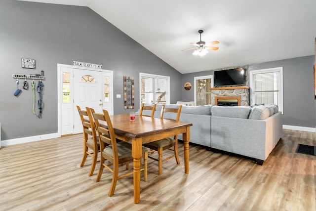 dining room with a fireplace, ceiling fan, plenty of natural light, and light hardwood / wood-style floors