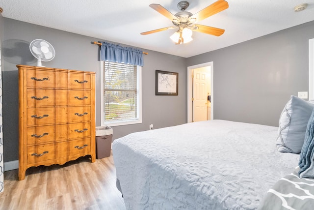 bedroom featuring ceiling fan, light wood-type flooring, and a textured ceiling