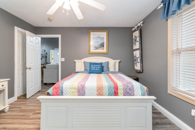 bedroom with light hardwood / wood-style flooring and ceiling fan