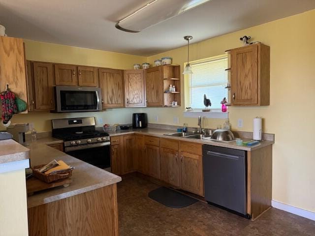 kitchen featuring appliances with stainless steel finishes, pendant lighting, and sink