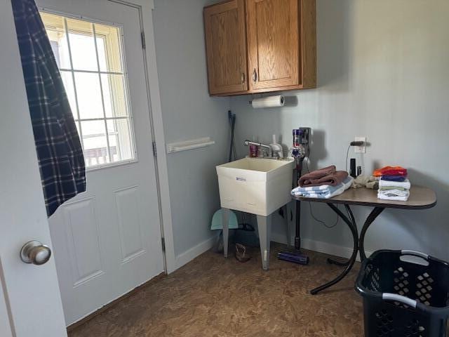 clothes washing area with cabinets