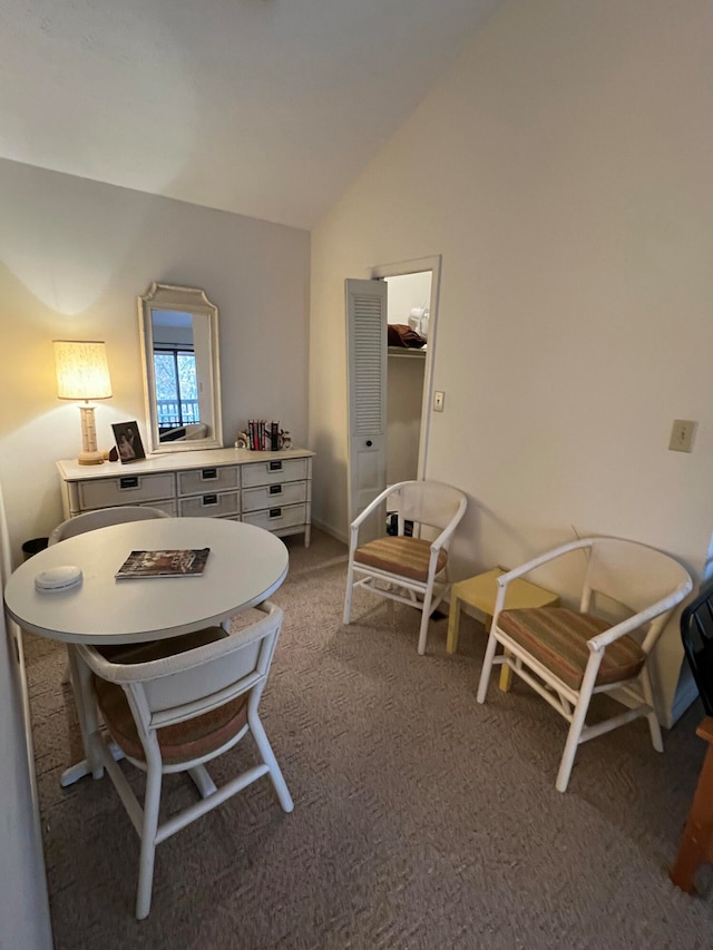 dining area with carpet floors and lofted ceiling