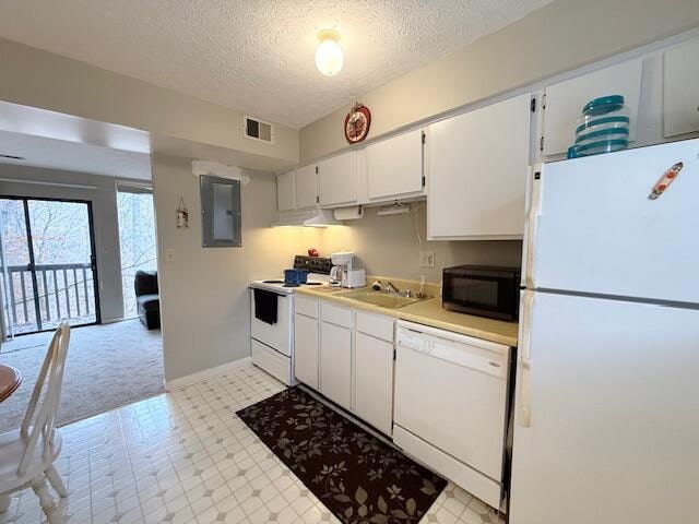 kitchen with white appliances, electric panel, sink, a textured ceiling, and white cabinetry