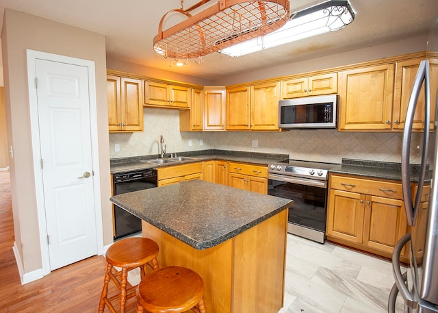 kitchen featuring stainless steel appliances, a center island, sink, and backsplash