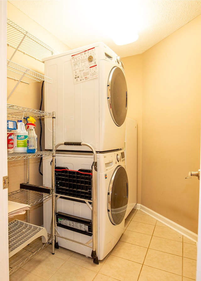 laundry room with stacked washer and dryer and light tile patterned flooring