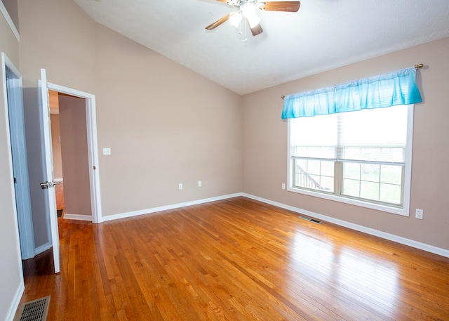 spare room featuring ceiling fan, vaulted ceiling, and wood-type flooring