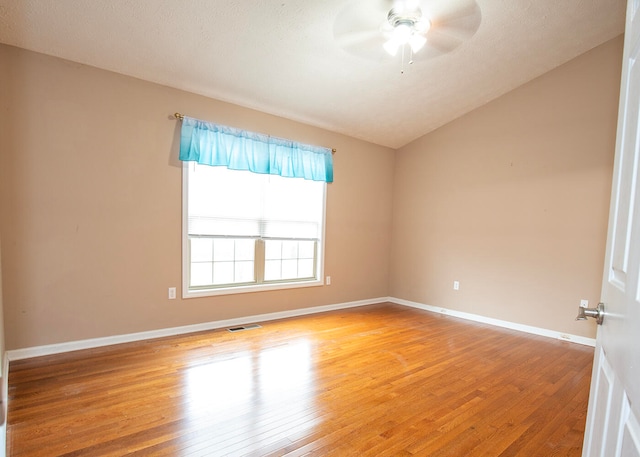 unfurnished room featuring lofted ceiling, a textured ceiling, hardwood / wood-style floors, and ceiling fan