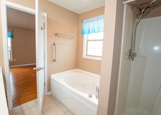 bathroom featuring a textured ceiling, separate shower and tub, and tile patterned floors